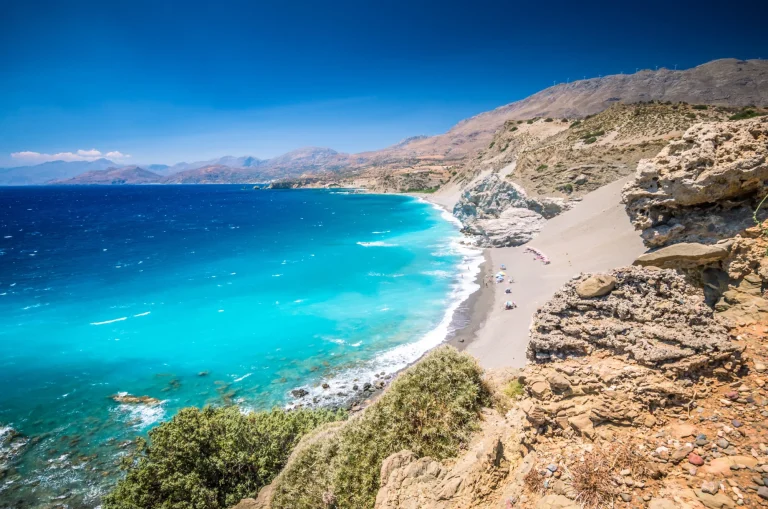 Strand von Agios Pavlos auf der Insel Kreta, Griechenland. Touristen entspannen und baden im kristallklaren Wasser des St. Paul Sandhill Beach.